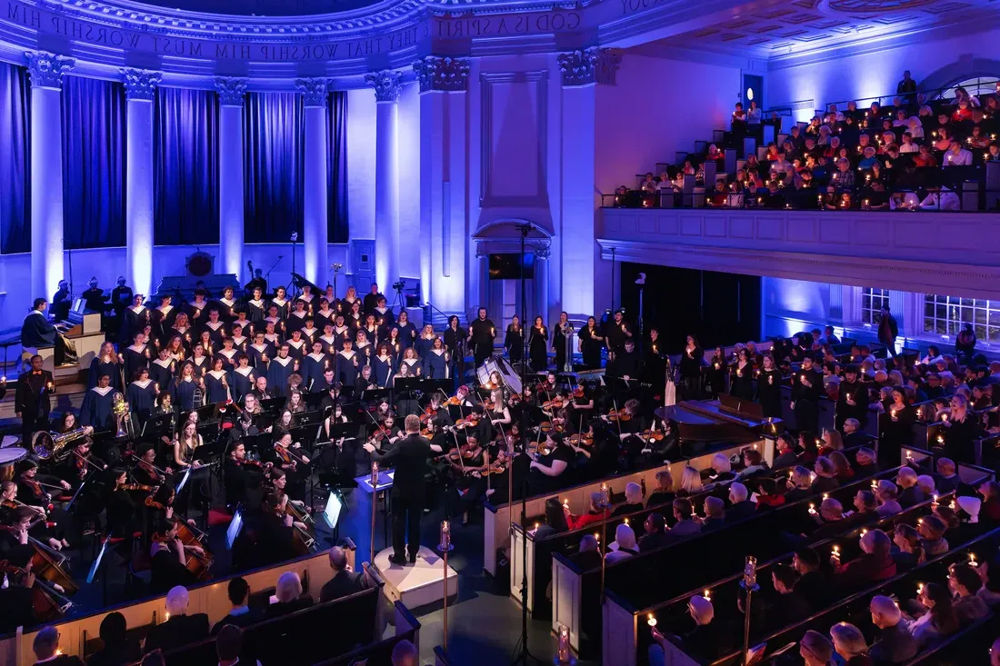 People singing in a choir in front of an audience.